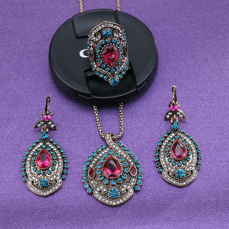 Jewelry set with necklaces and earrings featuring pink gemstones on a purple background