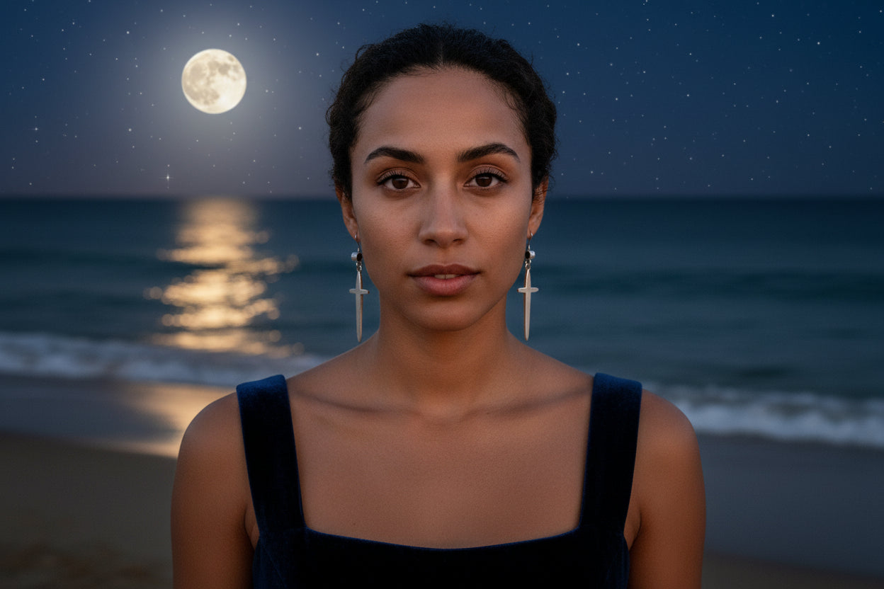 Woman with earrings standing on a beach at sunset