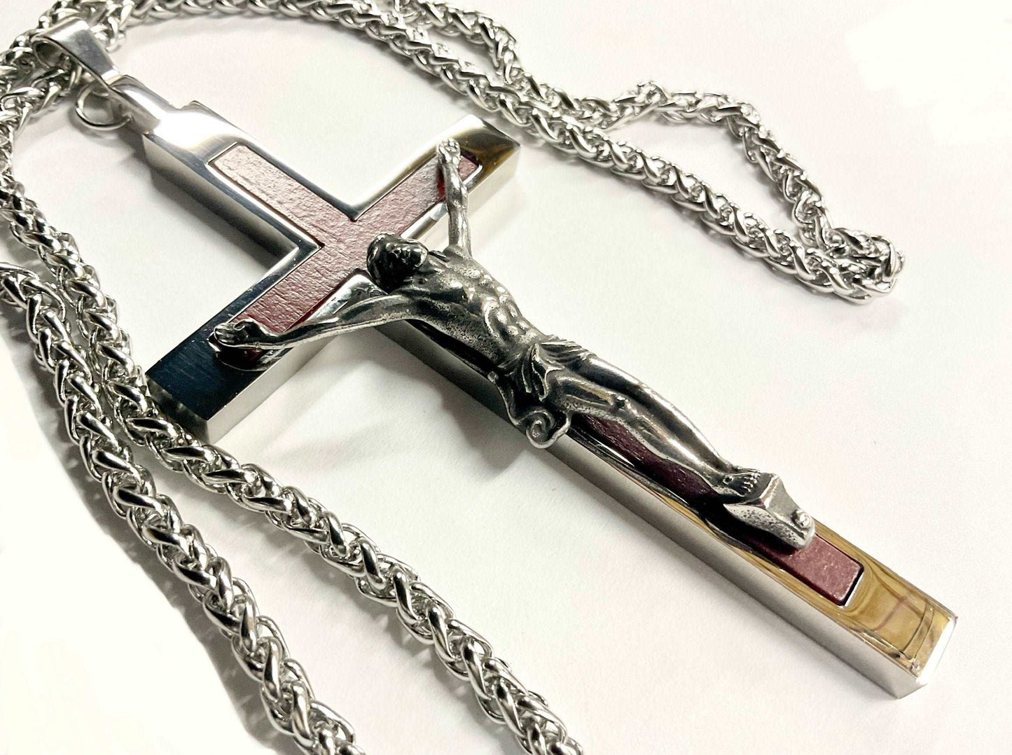 Silver crucifix necklace with chain on a white background