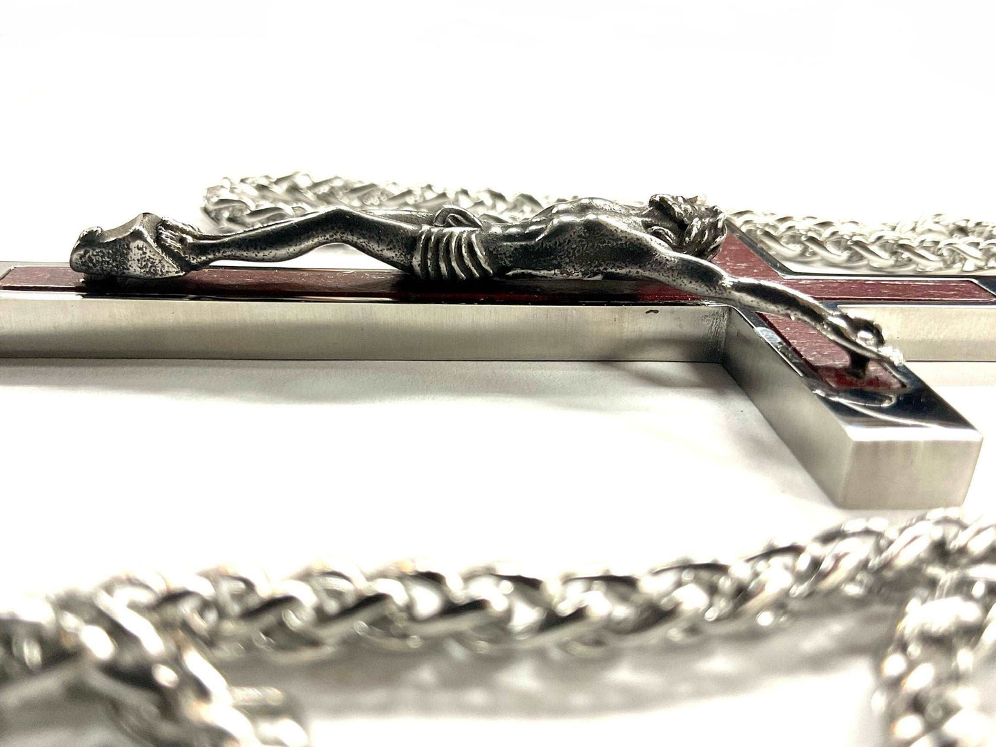 Silver crucifix with a chain on a white background